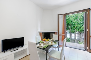 Enjoy a compact living space with a dining area and TV, perfect for relaxing and taking in the views of the surrounding greenery.