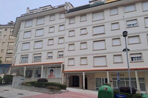 Ein mehrstöckiges Gebäude mit einheitlicher Fassade, einem zentralen Eingang und einem sichtbaren Schild mit der Aufschrift 'NOTARIA'.