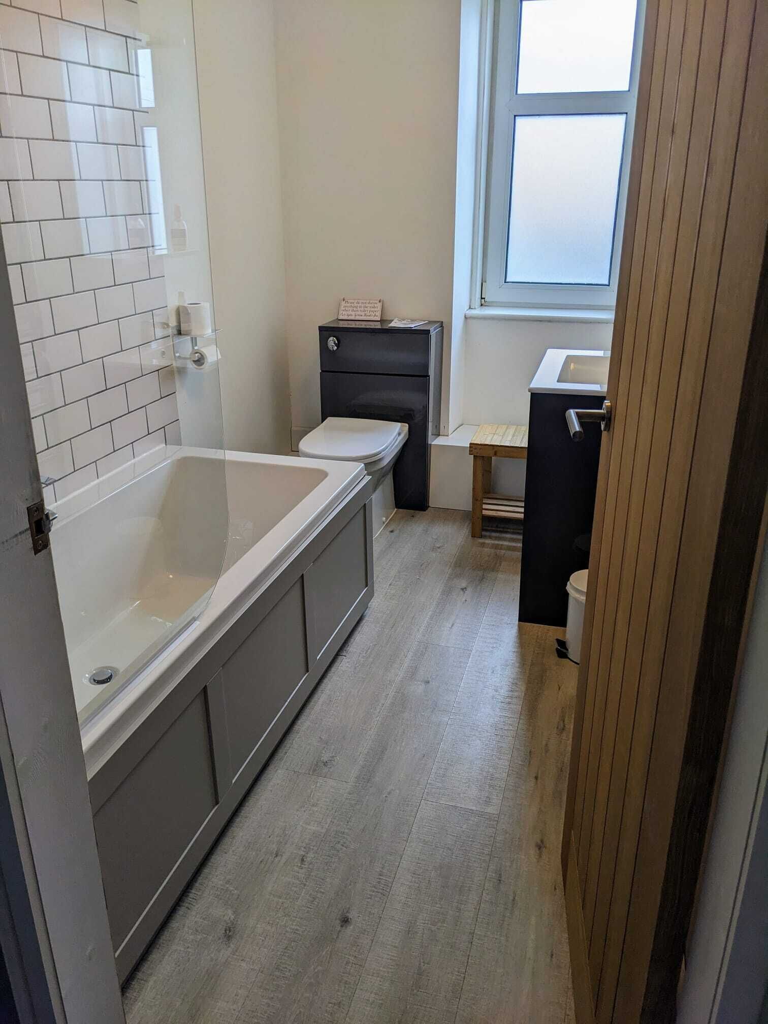 A bathroom with a bathtub, toilet, and sink.
