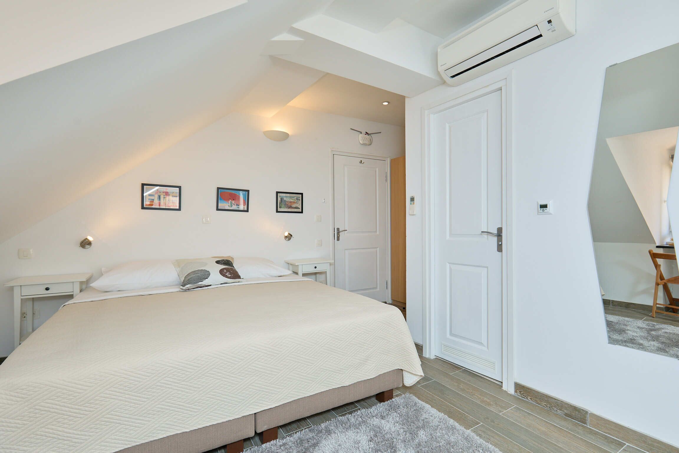 Un dormitorio con una cama grande, una puerta blanca y un ventilador de techo.