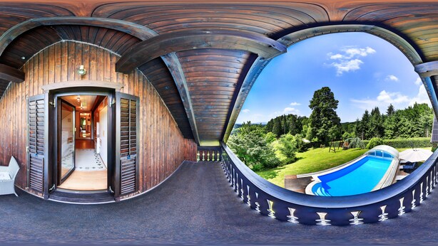 Een panoramisch uitzicht op een houten hut met een zwembad en een tuin.