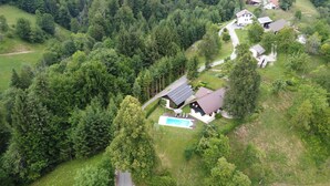 Luchtbeeld van een woongebied met huizen omgeven door dicht bos.