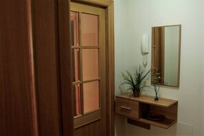 A wooden door with a glass panel, a wooden vanity with a mirror, a telephone, and a plant. - Disconnectaengalicia La Perla Superior, swimming pool and parking (Portonovo)