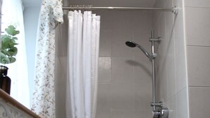 Une salle de bain avec une douche, un lavabo et un miroir.