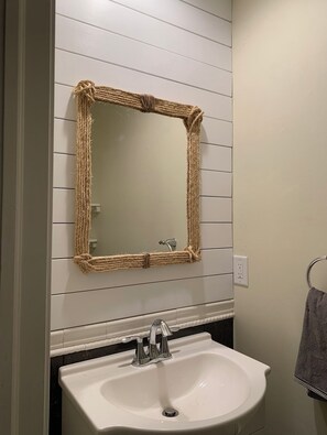 Een bad/douchecombinatie, een haardroger, handdoeken, zeep