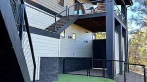 A two-story house with a covered outdoor area and artificial grass. - Carriage House (Show Low)