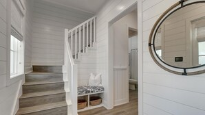 A staircase with white railings and a bench with cushions.