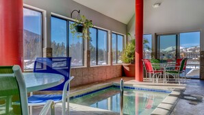 An indoor pool area with a view of mountains, a table with chairs, and a hanging plant. - Patio access to Keystone Lake & Gorgeous Views, Easy Access to Everything! (Keystone)