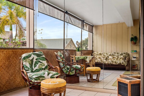 Relax on the balcony with a comfortable seating area, wicker chairs, and a sofa, perfect for dining or enjoying a drink.