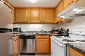 Kitchen equipped with a stove, dishwasher, and microwave, featuring modern fixtures and cabinetry.