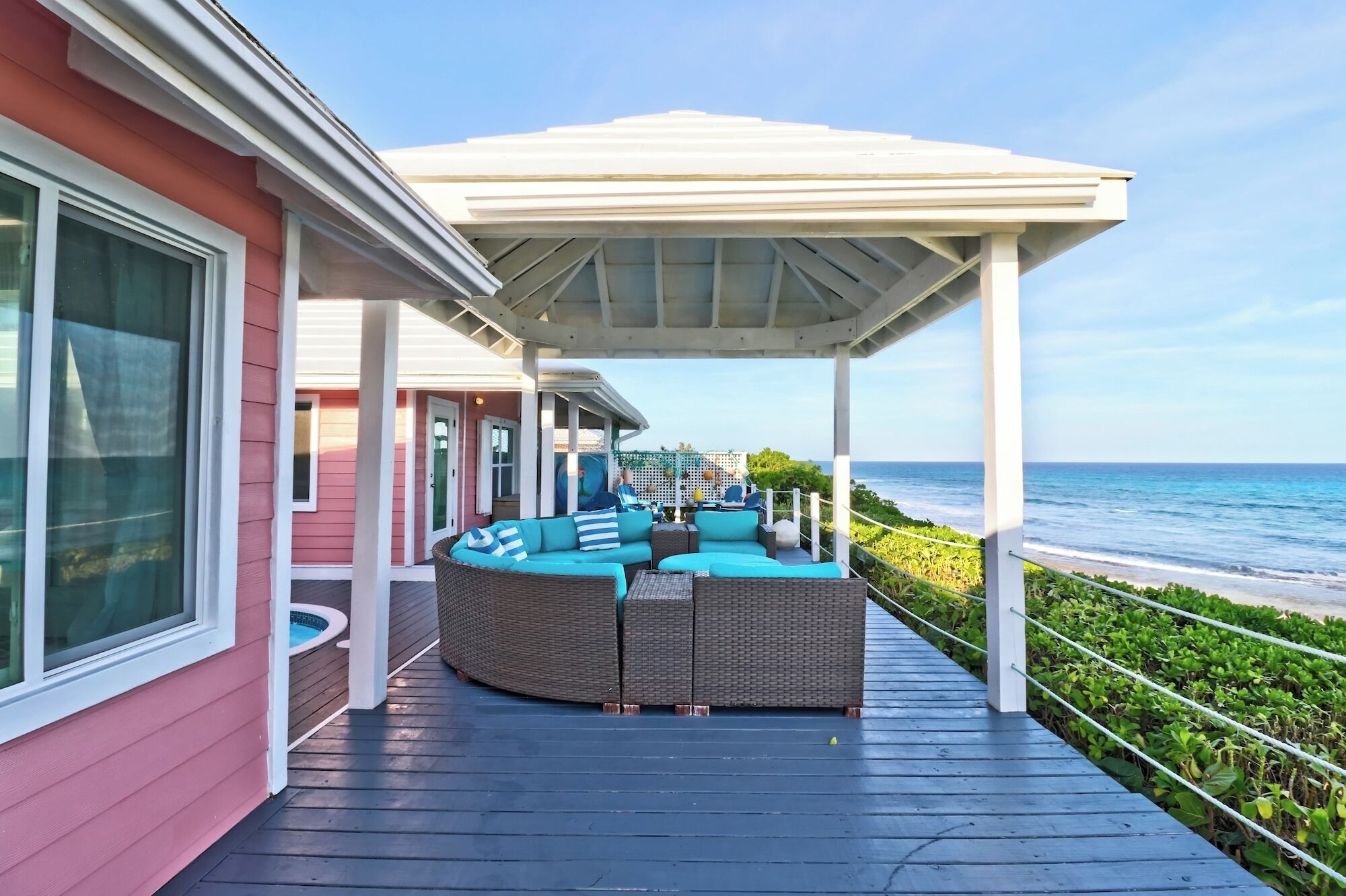 A covered outdoor seating area with a view of the ocean.