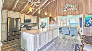 A spacious kitchen with a large island, wooden ceiling beams, and a view to a balcony. - Endless Summer - Perfect Getaway near Tahiti Beach (Hope Town)