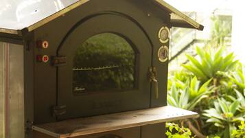 A vintage outdoor oven with a wooden door and a metal chimney.