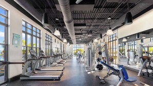 Een moderne sportschool met loopbanden, krachttrainingsapparatuur en fitnessmaterialen.