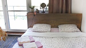 A bedroom with a bed, pillows, a bedside table, a mirror, and a view of the outdoors through a sliding door. - Terrace with gorgeous panorama in historic Rabstejn (Manetín)