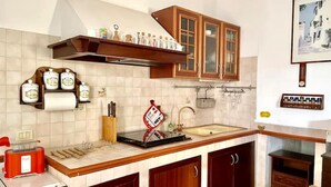 A kitchen with wooden cabinets, a built-in oven, and a sink. - Sabaudia Holiday home Il Maestrale (Lazio)