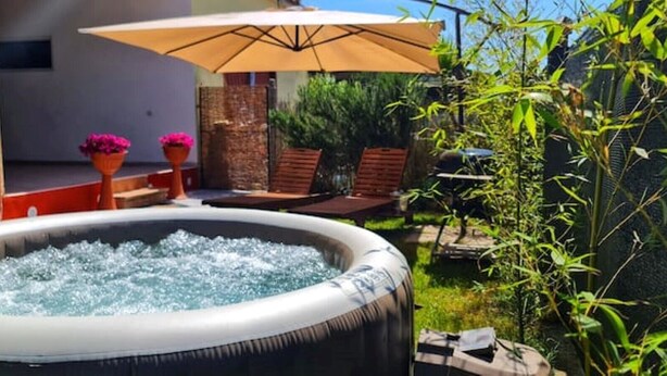 An outdoor hot tub surrounded by potted plants and a bamboo fence. - Sabaudia Holiday home Il Maestrale (Lazio)