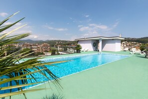 A rooftop pool with a clear view of the surrounding buildings and hills.