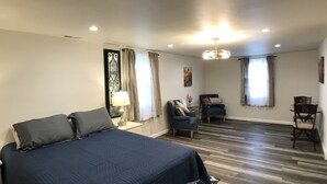 A hotel room with a large bed, a desk, two chairs, a lamp, and a painting on the wall. - Upnorth with a dockslip (St. Helen)