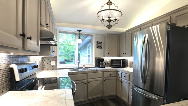 A modern kitchen with stainless steel appliances, a marble countertop, and a window providing natural light. - Upnorth with a dockslip (St. Helen)