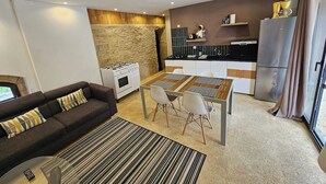 Una sala moderna con un sofá, una mesa de centro y un comedor con sillas y una mesa.