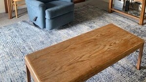 A living room with a stone fireplace, a blue armchair, a wooden coffee table, and a television on a wooden stand. - 4302  Hot tub, sauna & more resort amenities  Grandfather View @ Pinnacle (Beech Mountain)
