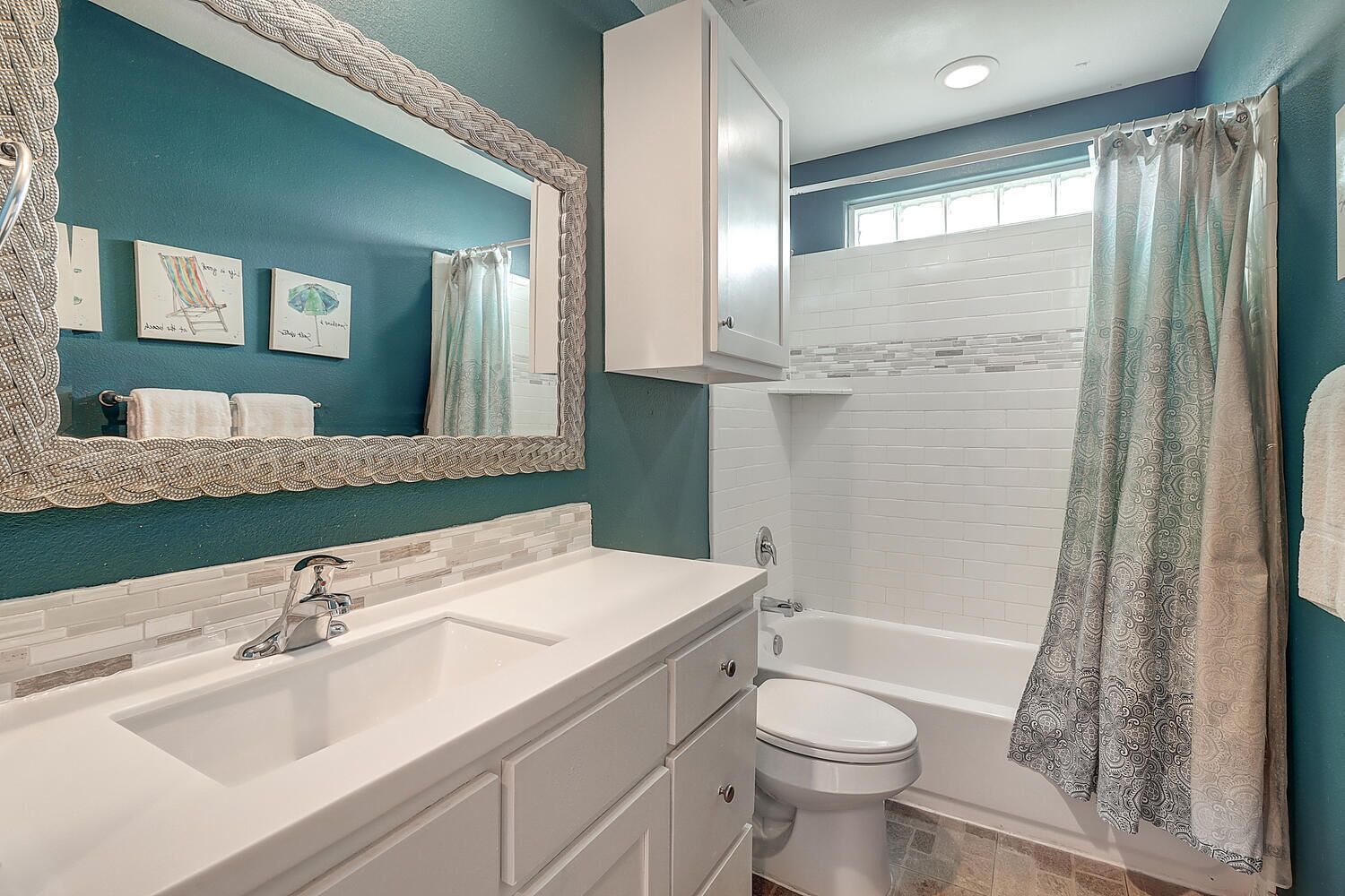 Une salle de bain avec un grand miroir, deux lavabos, des toilettes et une baignoire.