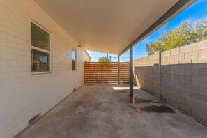 Enjoy the serene atmosphere of this outdoor space with a covered area and a wooden fence.