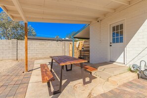 Enjoy dining or socializing in this outdoor space with a wooden table and benches.