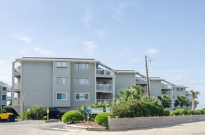 Un hotel de varios pisos con balcones, un estacionamiento y un letrero que dice 'The Breakers'.