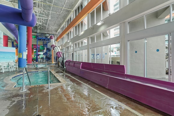 An indoor water park with a pool, slides, and a play area. - Dunes Village by Elliott Beach Rentals (Myrtle Beach)