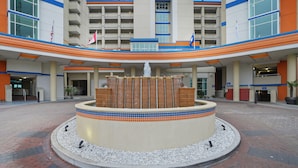 A hotel with a central fountain, multiple floors, and a parking garage. - Dunes Village by Elliott Beach Rentals (Myrtle Beach)