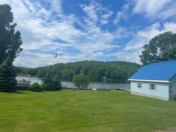 A lakeside property with a house, a dock, and a flag. - Historic Cottage- near Saratoga- on Summit Lake (Argyle)
