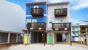 A two-story building with balconies, a covered entrance, and a gravel driveway. - ~No Bad Days Townhome~ - 300ft to the sand! (Mexico Beach)