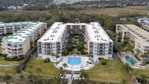 Ein großes Resort mit mehreren Gebäuden, einem zentralen Pool und einem Strandbereich.