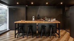 A modern kitchen with a central island, black bar stools, and a large window. - Seekers Finders Rama IV Hotel, SureStay Collection by BW (Bangkok)