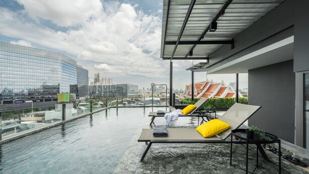 A rooftop infinity pool with lounge chairs and a city view. - Seekers Finders Rama IV Hotel, SureStay Collection by BW (Bangkok)