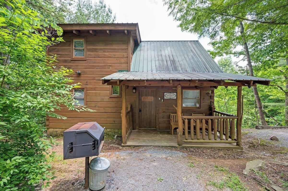 A rustic cabin with a porch and a mailbox.