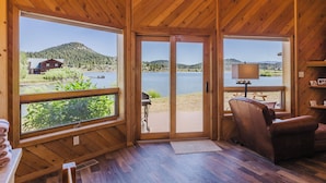 A wooden cabin with large windows, a wooden ceiling, and a view of a lake and mountains. - On Lake Hatcher. Fish right from home. Hot Tub. (Pagosa Springs)