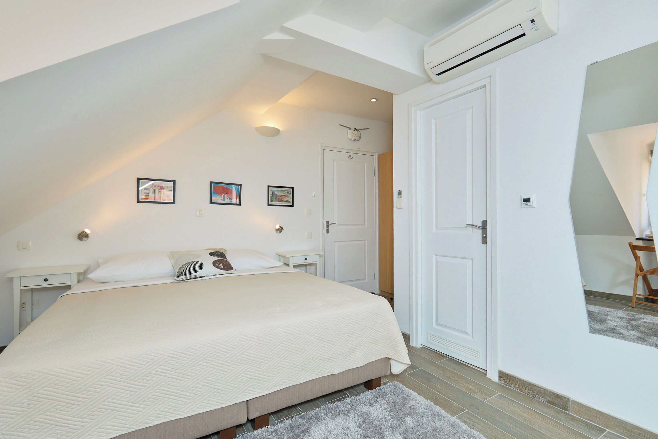 Una camera da letto con un letto grande, una porta bianca e una ventola a soffitto.