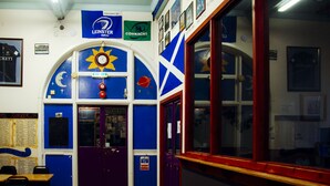 A room with a purple door, a blue wall with a sun design, and a flag. - Belford Hostel (Edinburgh)