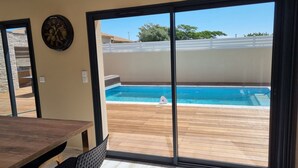 A room with a sliding glass door leading to a swimming pool area. - La Villa Manon - FLORENSAC (Florensac)