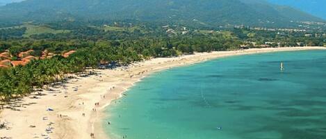 A coastal beach with a mountain in the background.