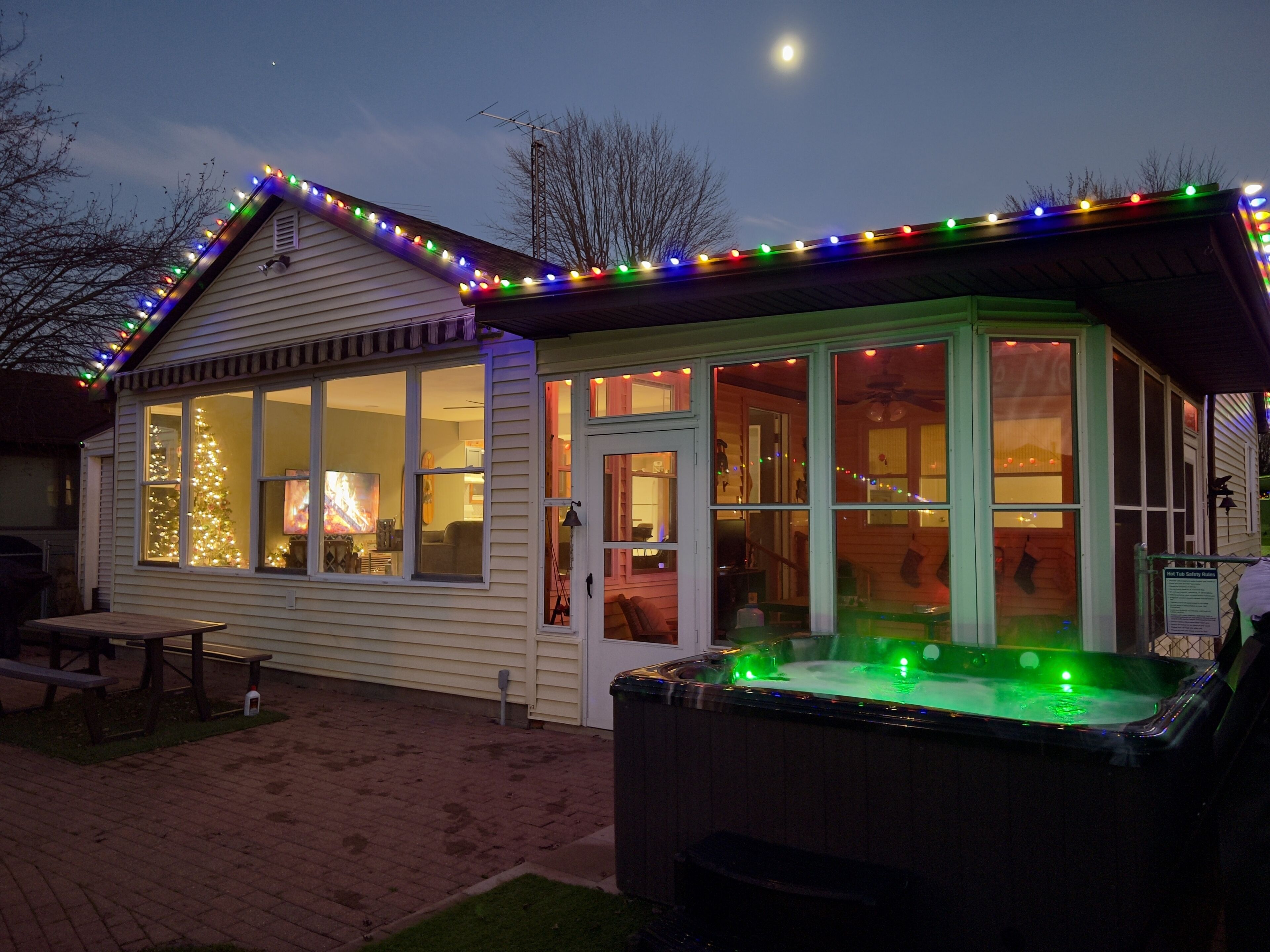A small, single-story building with a hot tub and a Christmas tree.