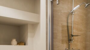 Een moderne badkamer met een douchecabine van glas, een witte badkuip en een toilet.