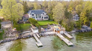 Une propriété au bord du lac comprenant une maison principale, une maison d’hôtes et une jetée qui s’avance dans l’eau.