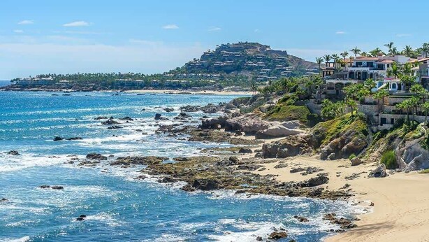 A coastal hotel with a rocky shoreline, beachfront views, and a hilltop location.