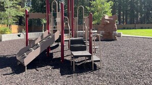 Une aire de jeux avec un toboggan, des structures d’escalade et un espace de jeux couvert.