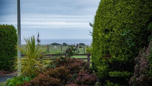 Un jardín bien cuidado con diversas plantas y una cerca de madera.