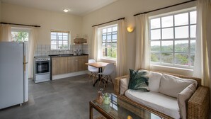 A modern kitchen with a dining area, a sofa, and large windows. - Apartment in the gated compound Jan Sofat near Jan Thiel Beach (Willemstad)